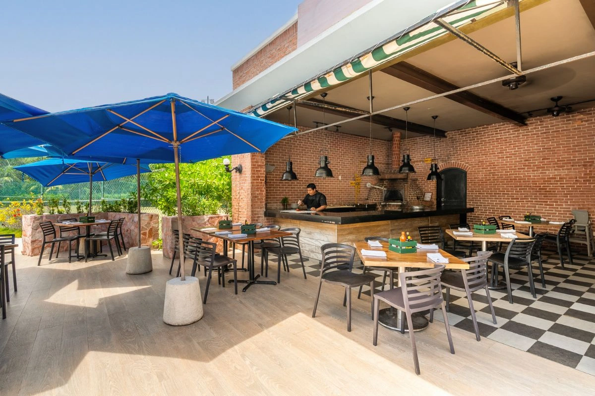 Eating a delicious pizza in the outdoors restaurant with open kitchen
