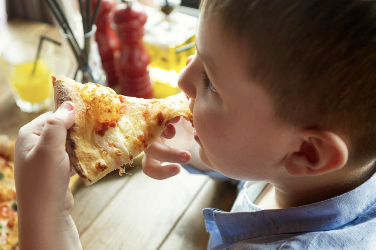 Kid enjoying a pizza in Al Forno restaurant
