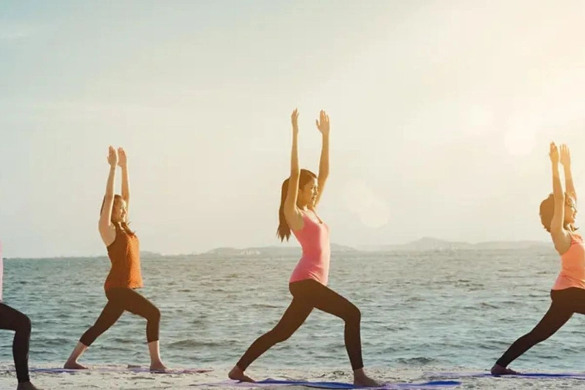 Women doing yoga on the beach