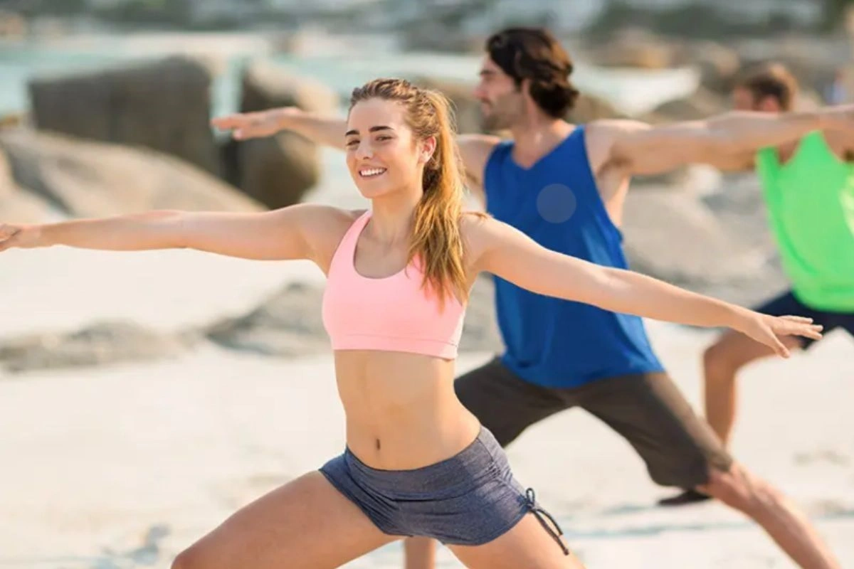 Couple doing yoga in front of the sea