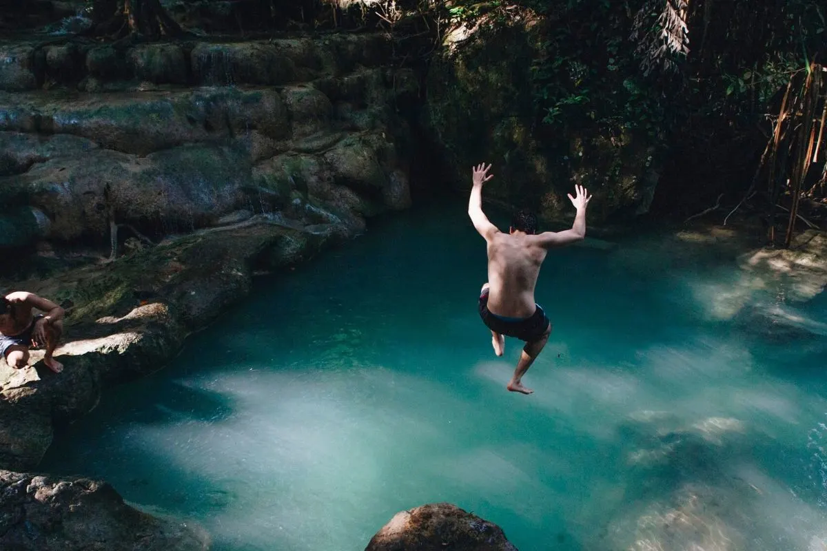 Tourist jumping to the water at a mayan cenote