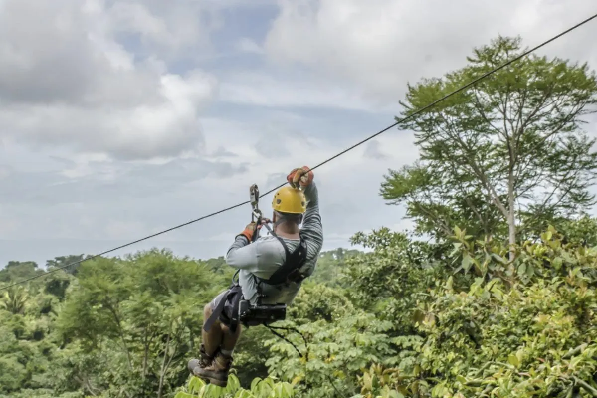 Tourist diving through the rain forest on a zip line