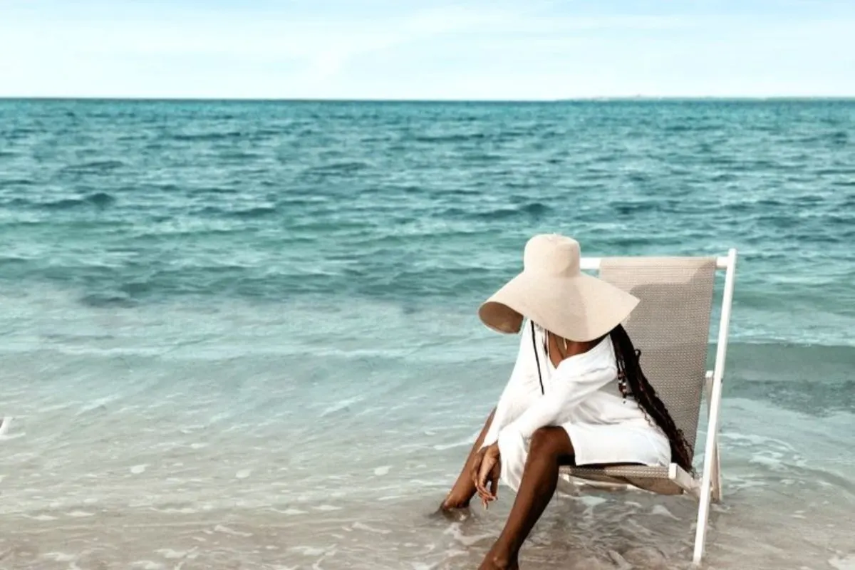 Woman sitting on a beach chair enjoying the water on her feet